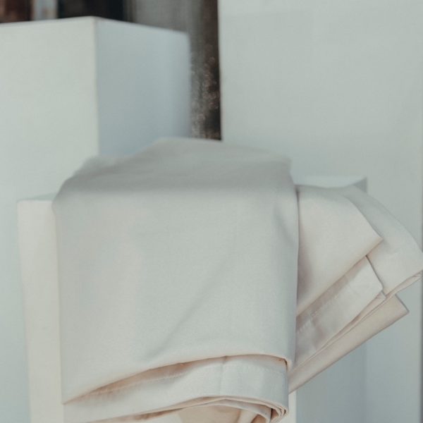 Gefaltete Tischdecke in Champagner-Sand mit leichtem Satin-Schimmer im Detail